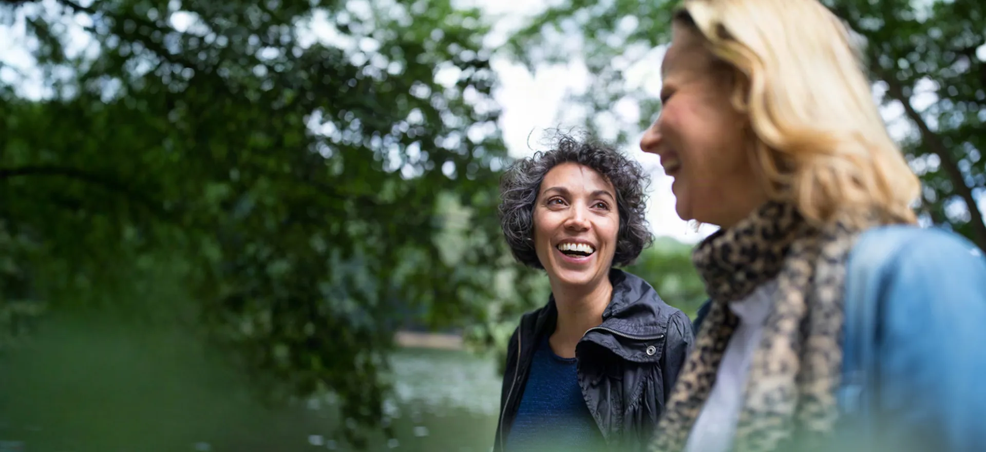 two friends smiling in a nature setting