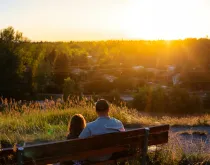 father and daughter on bench at sunset