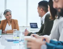 Mature woman and business people in meeting in discussion together