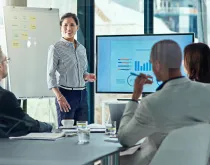 woman presenting data to coworkers in meeting