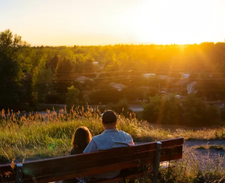 father and daughter on bench at sunset