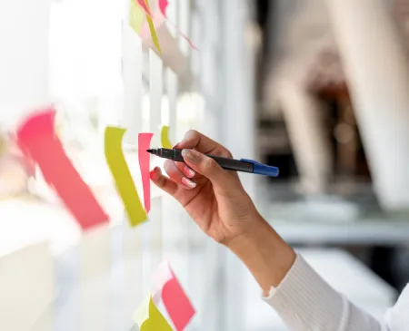 business woman writing on sticky notes on a board