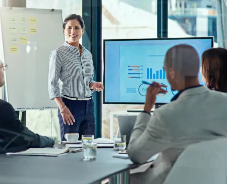 woman presenting data to coworkers in meeting