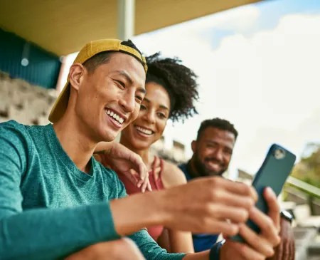 friends smiling at phone in arena