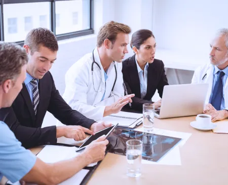 doctors and execs talking at table