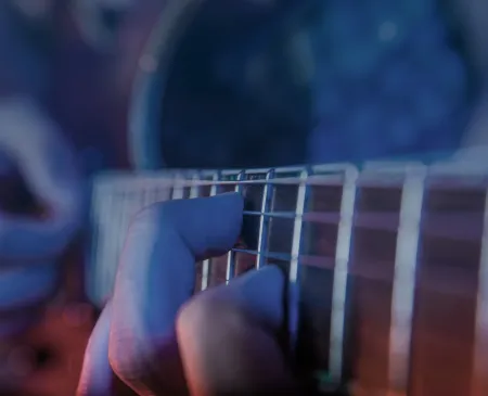 close up of hands playing guitar