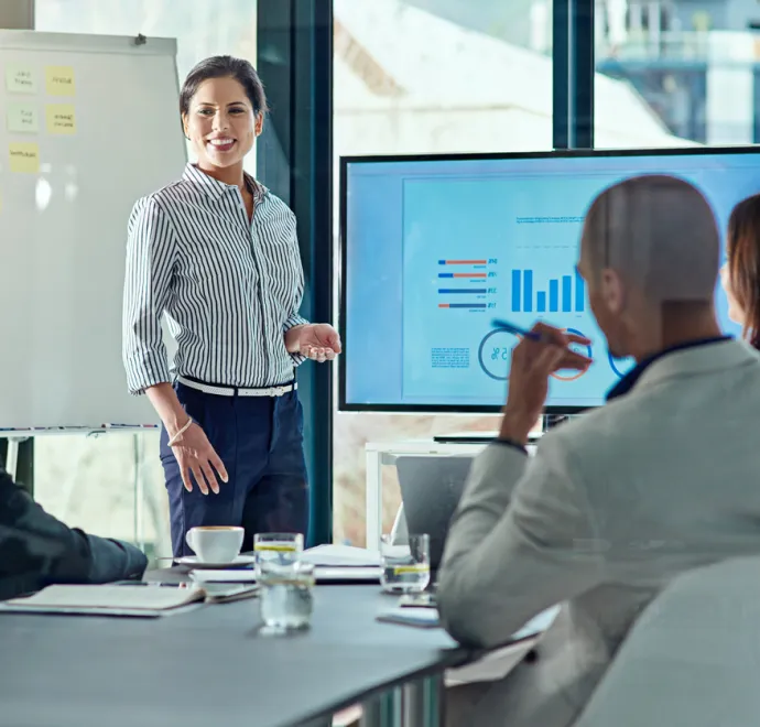 woman presenting data to coworkers in meeting