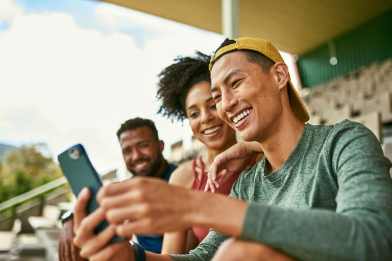friends smiling at phone in arena