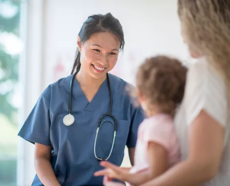 doctor or nurse talking with child and mom