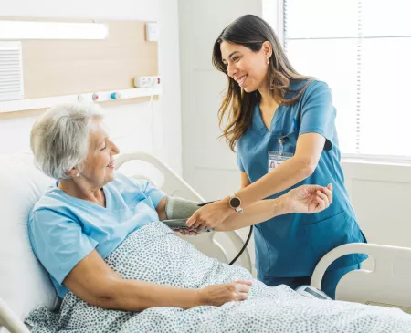 Nurse taking elderly woman blood pressure