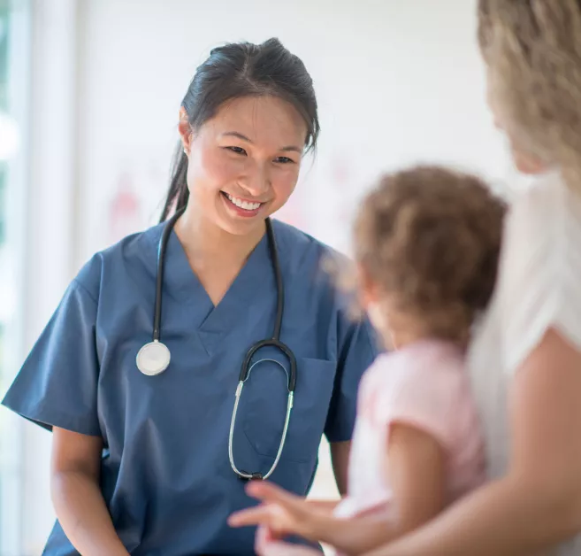 doctor or nurse talking with child and mom